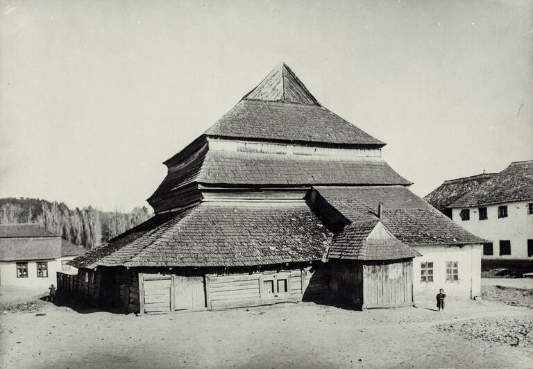 Photograph of wooden building exterior with several layers of roofs.