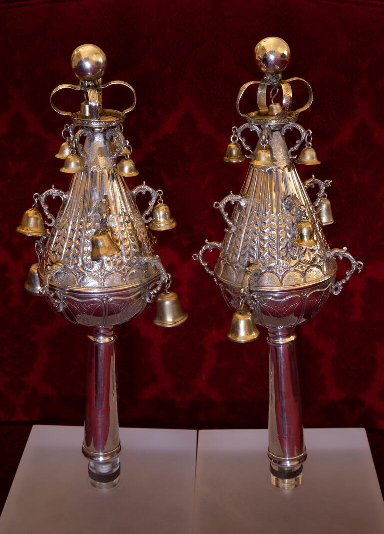 Two silver finials with bells. 