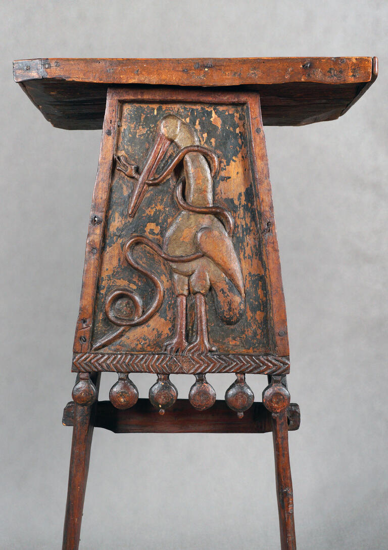 Wooden lectern with stork carving.