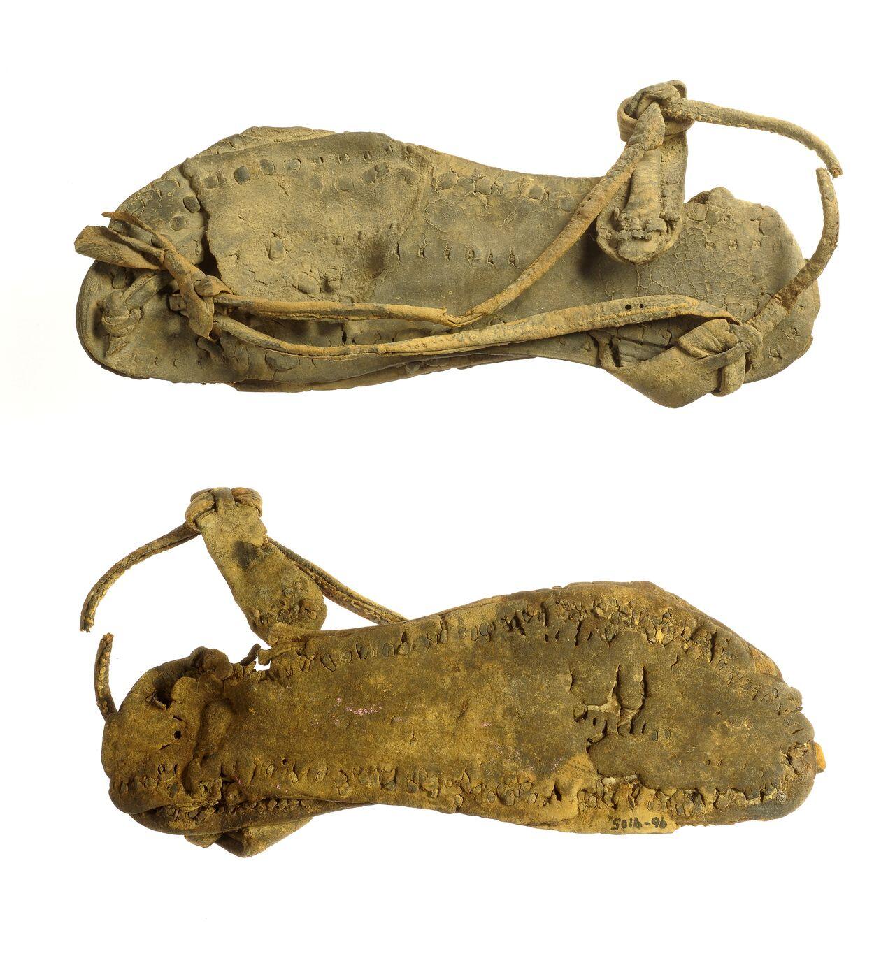 Two views of a single leather sandal. 