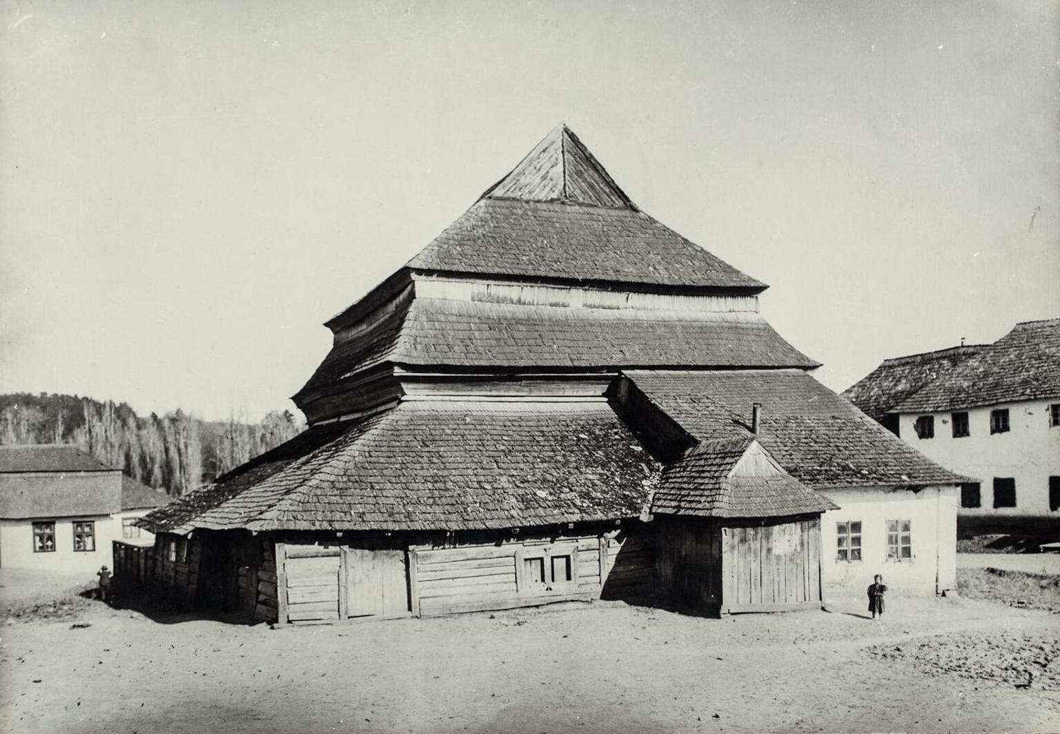 Photograph of wooden building exterior with several layers of roofs.