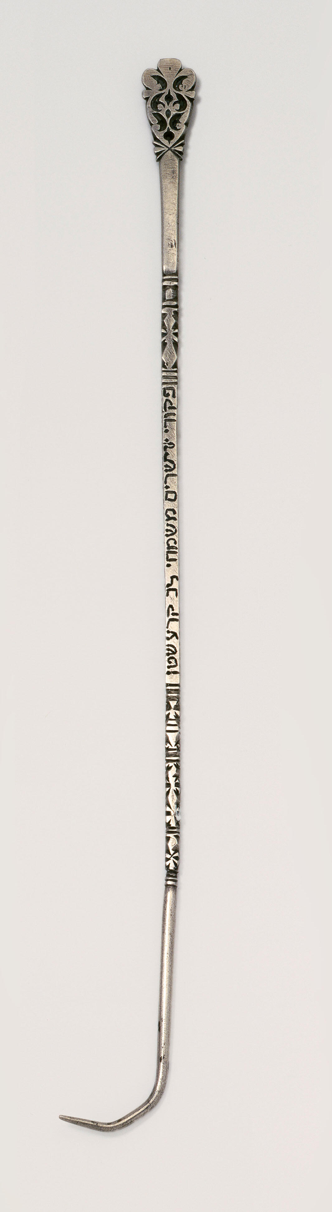 Silver pointer with hand at end and chain at top. Silver pointer with hand at end and chain at top.
