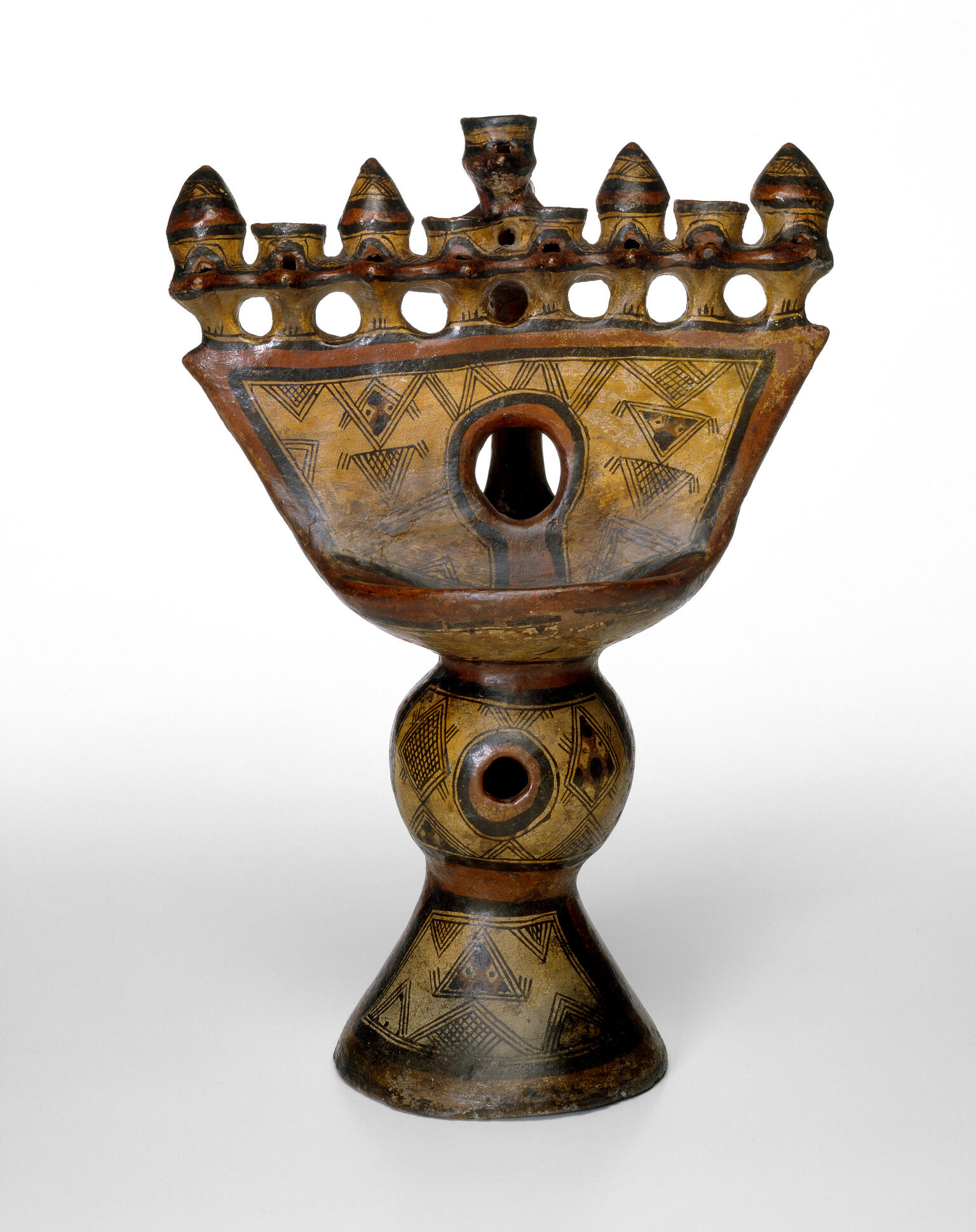 Oil lamp with geometric carvings.