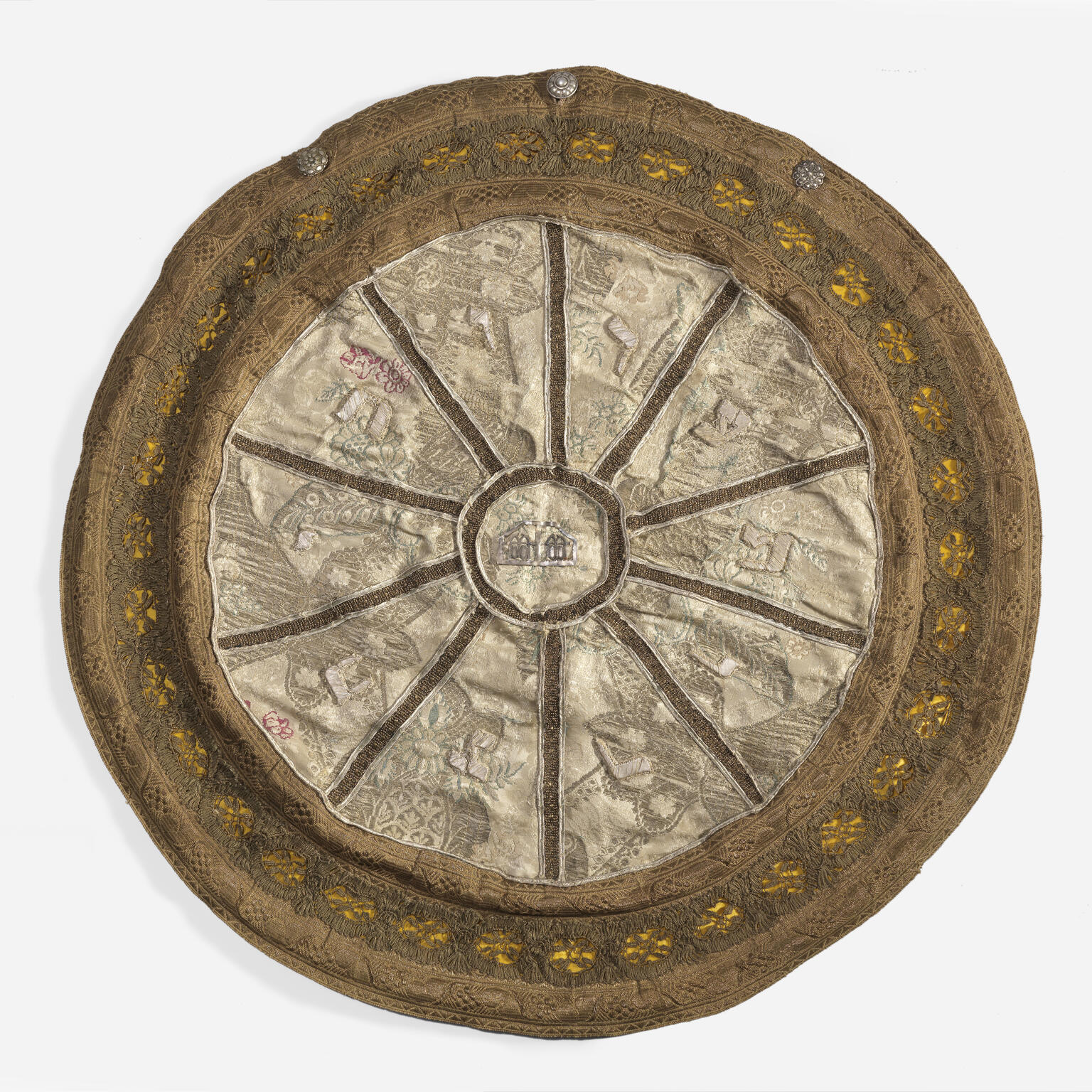 Cloth circular bag embroidered with radial sections and designs. 