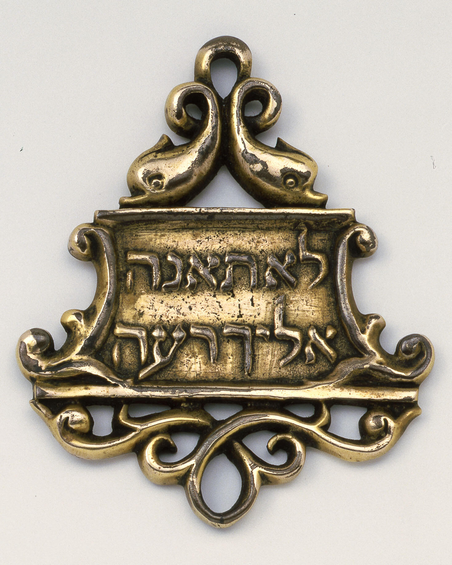 Bronze amulet with decorative border and Hebrew inscription. Bronze amulet with decorative border and Hebrew inscription.