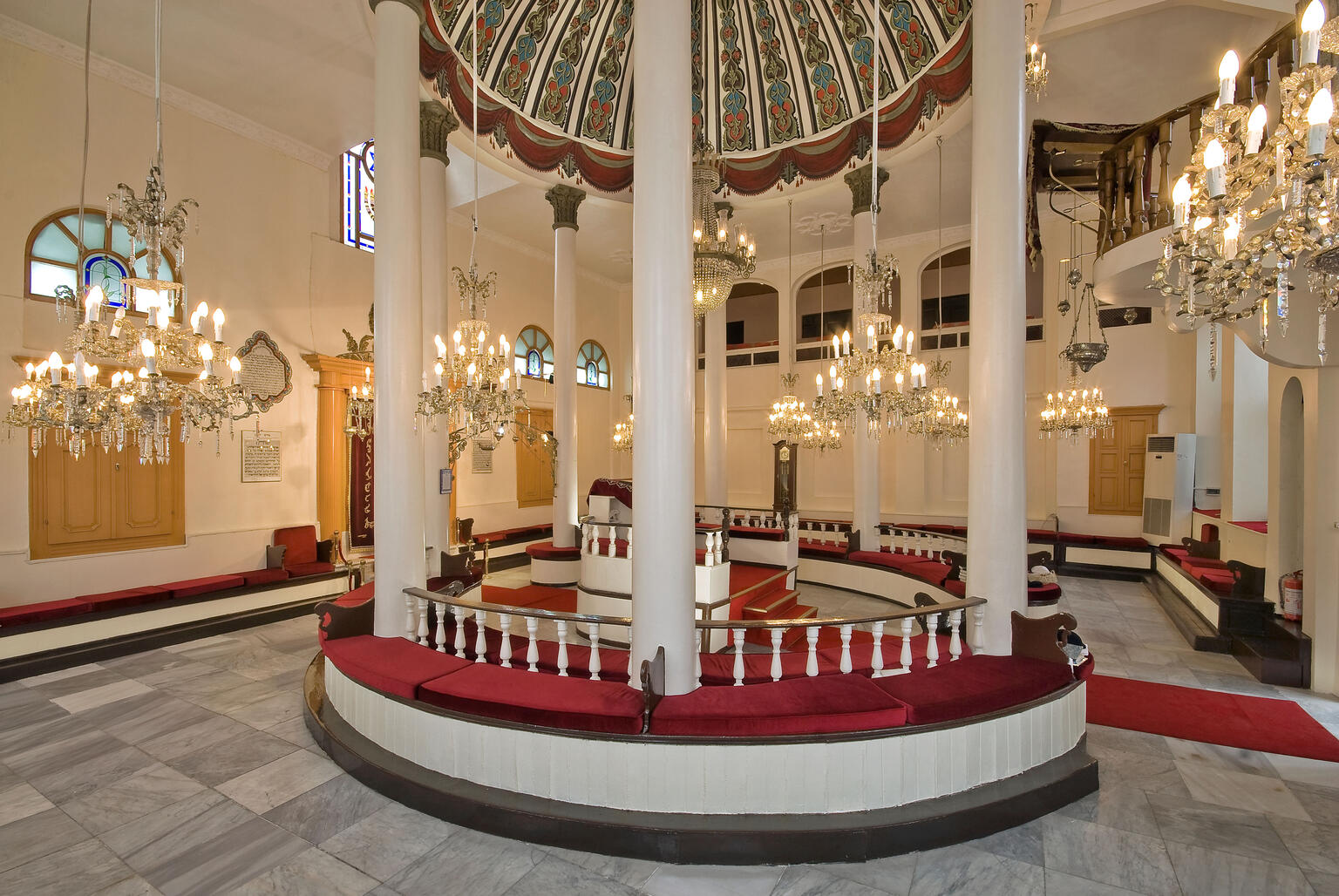 Room interior with central podium with tall columns and many chandeliers surrounding. Room interior with central podium with tall columns and many chandeliers surrounding.