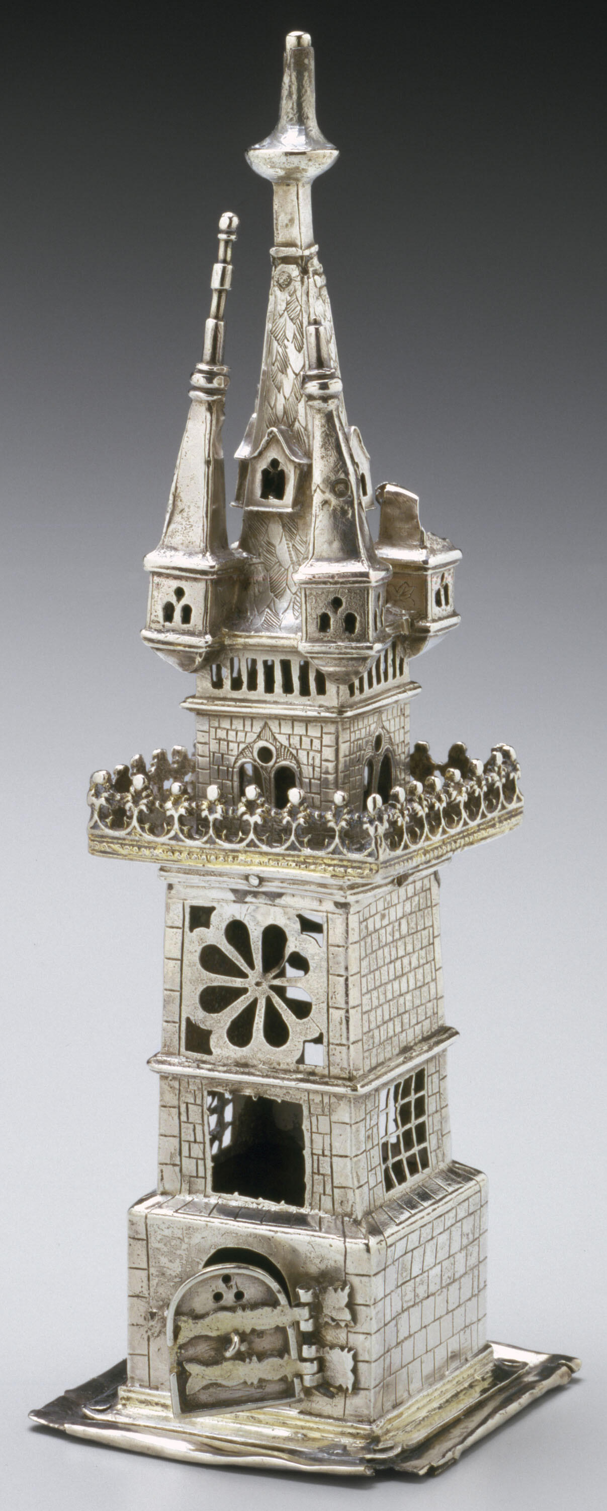 Container in the shape of a four-story tower with doors and windows cut out. 