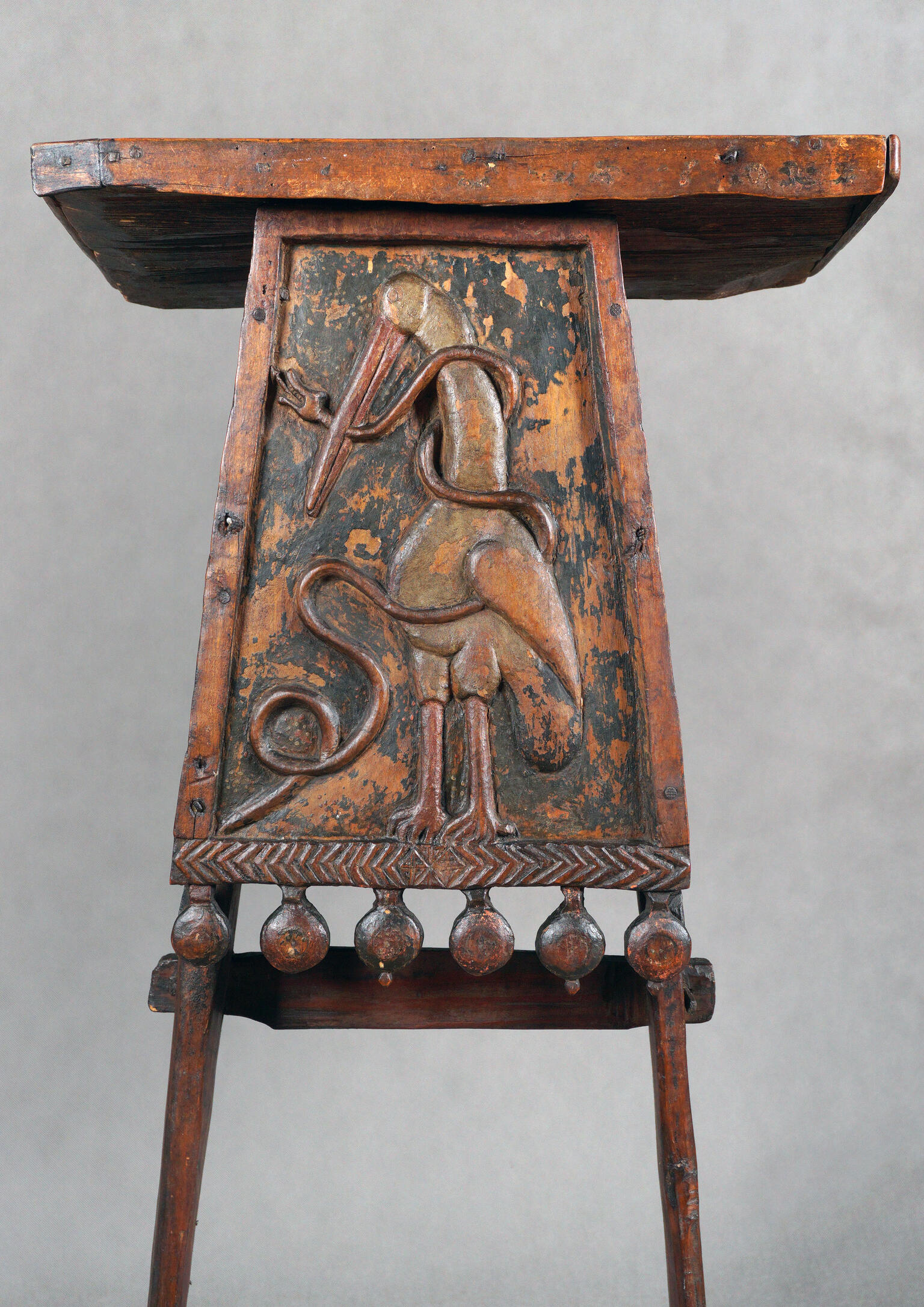 Wooden lectern with stork carving.