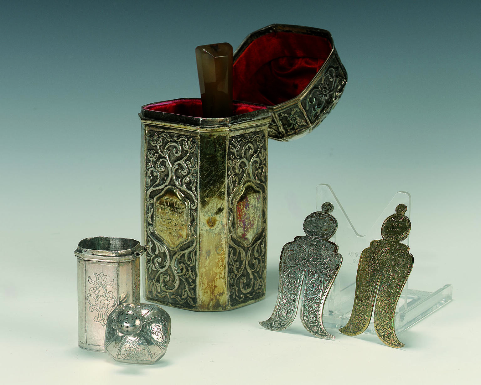 Set of objects: a box lined with velvet, a small box with lid next to it, and two small shields. 