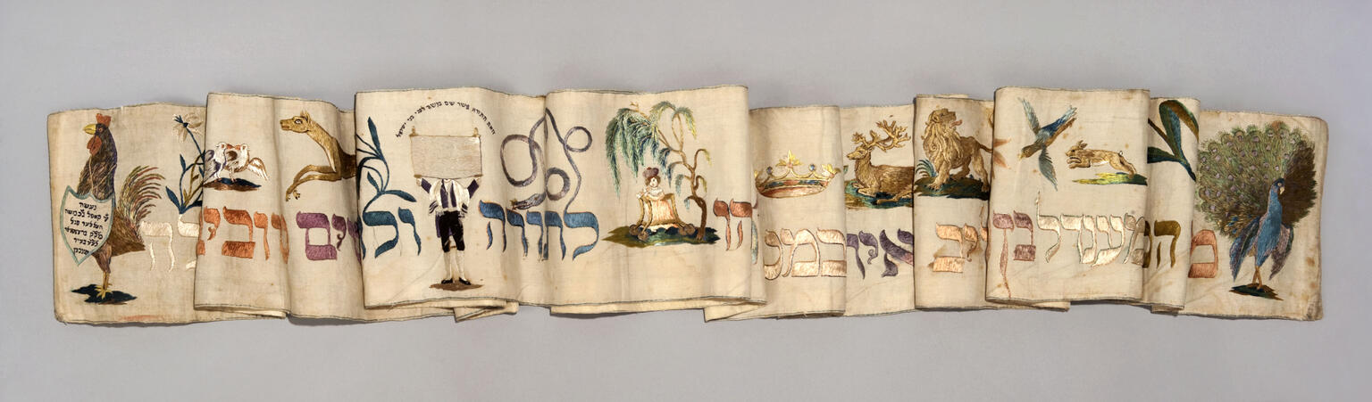 Textile featuring paintings of various animals and a crown.
