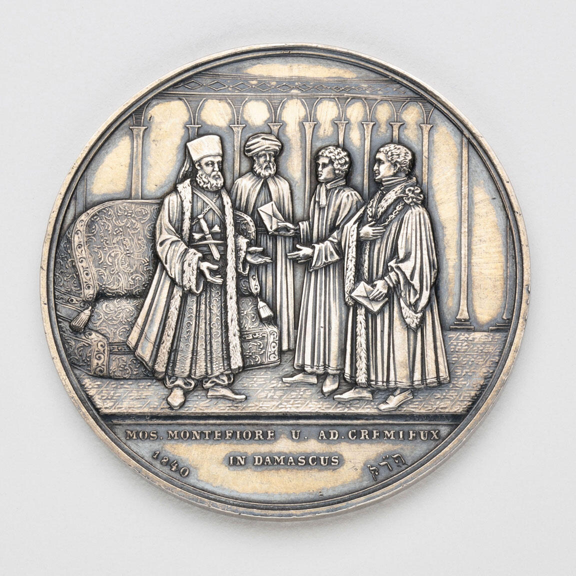 Silver medal depicting four men talking. Silver medal depicting four men talking.