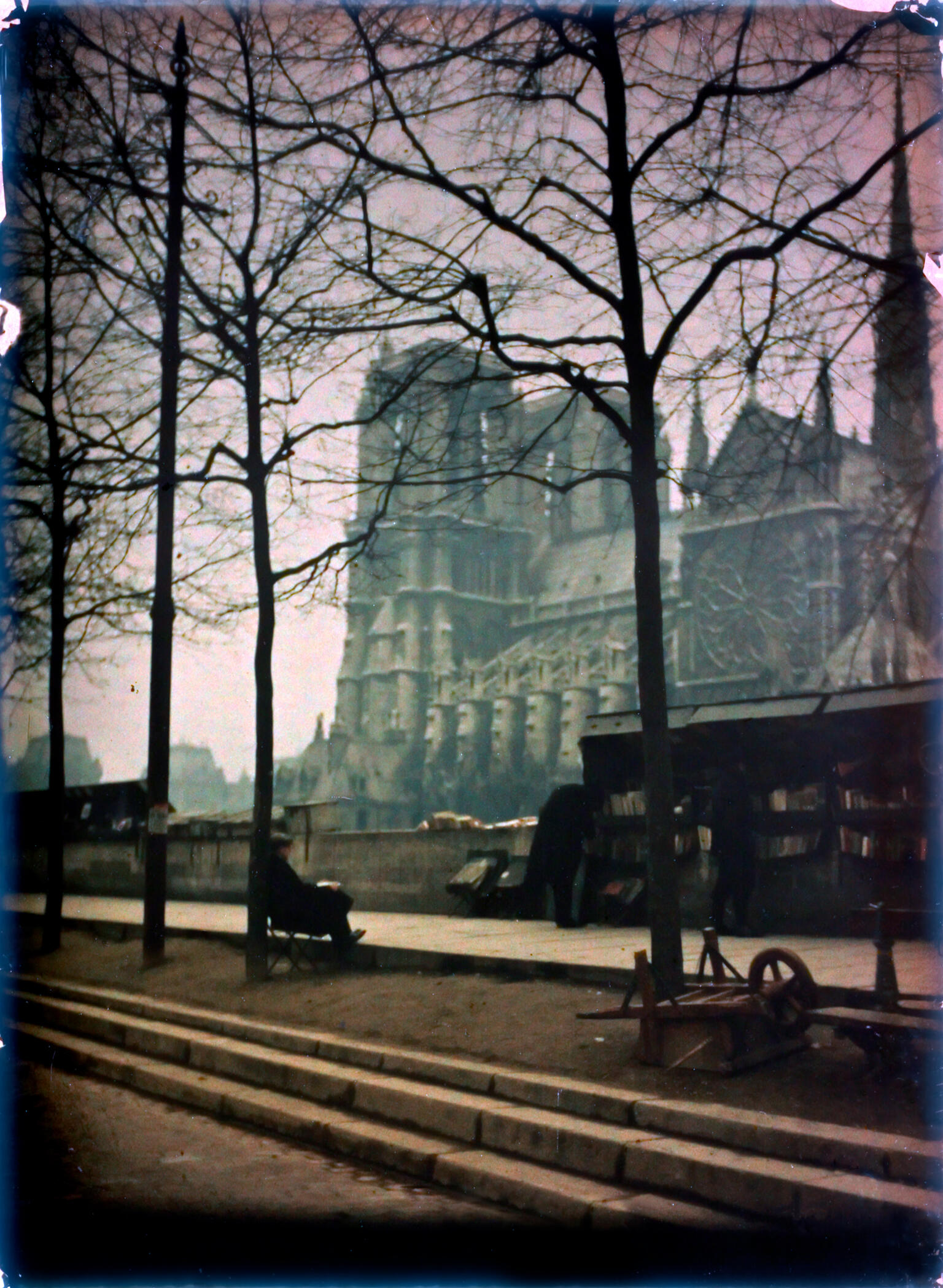Photograph of a sidewalk and large cathedral looming behind it.