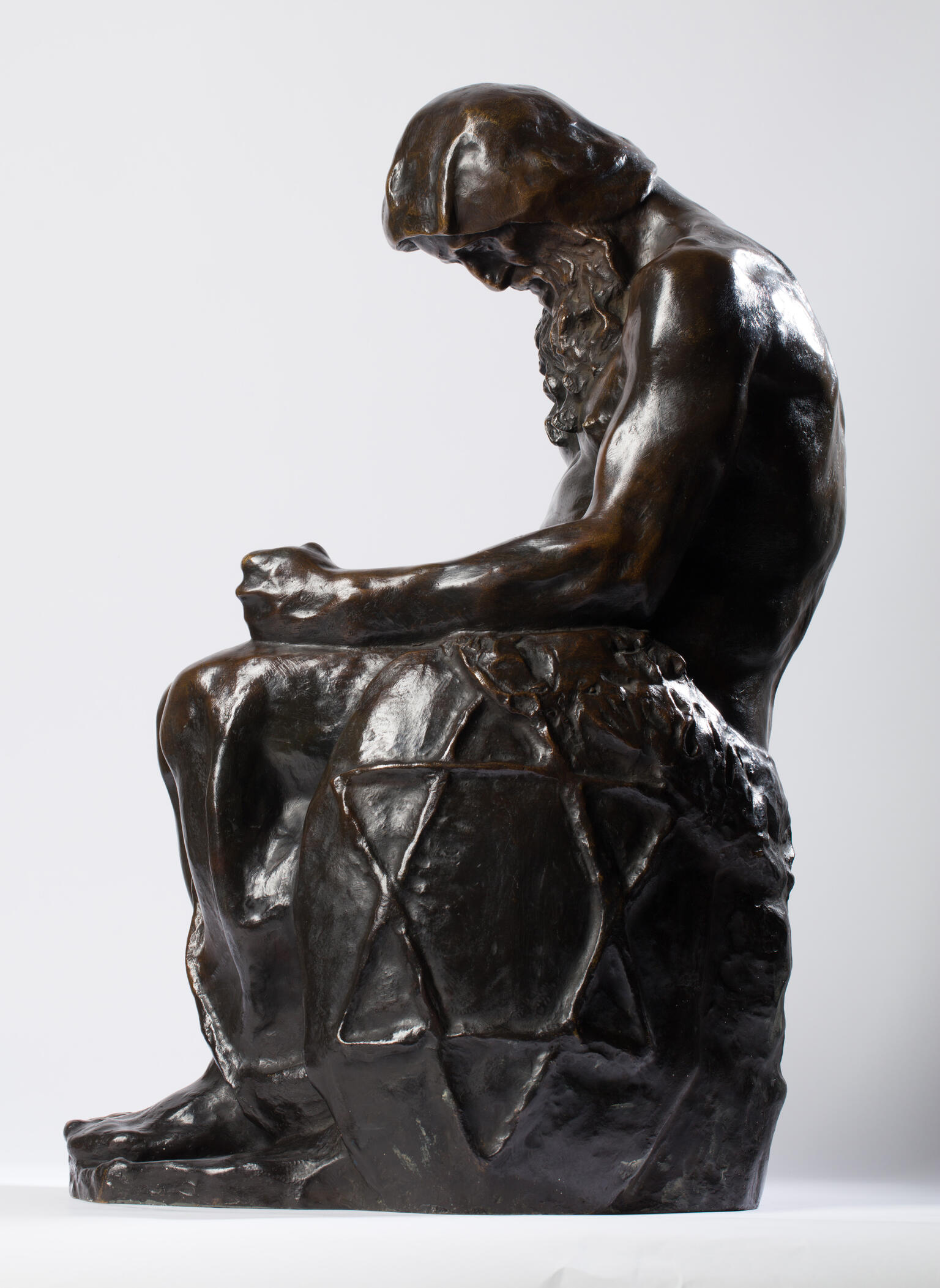 Bronze sculpture of seated figure with beard and Star of David etched onto its side. Bronze sculpture of seated figure with beard and Star of David etched onto its side.