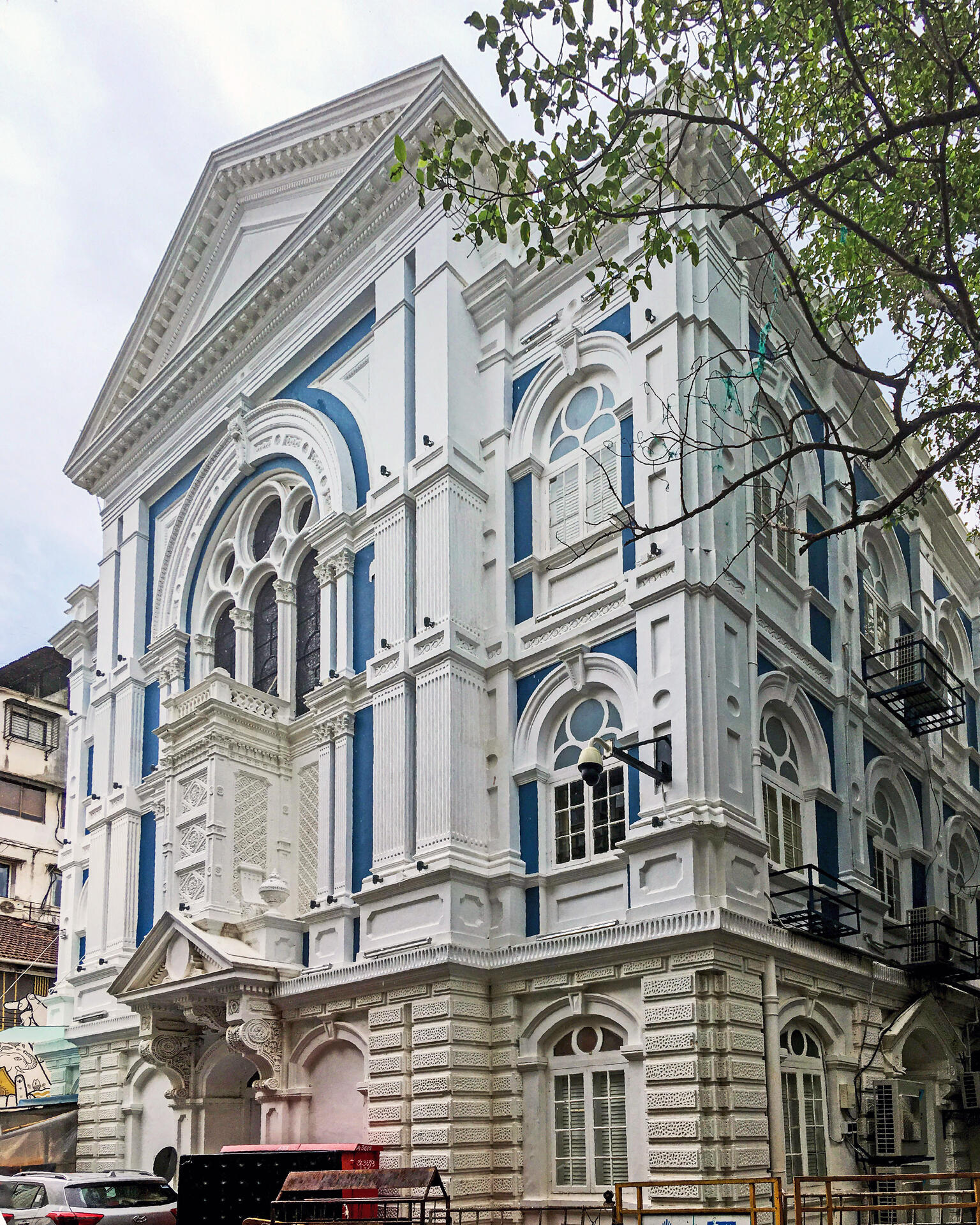 Photograph of building façade with significant decorative trim on window frames and beams.