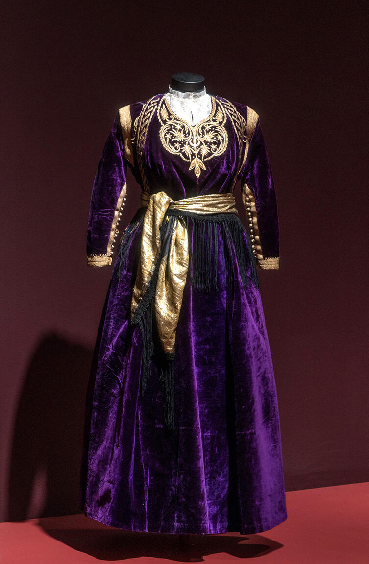 Dress with sash and embroidered neckline and sleeves.