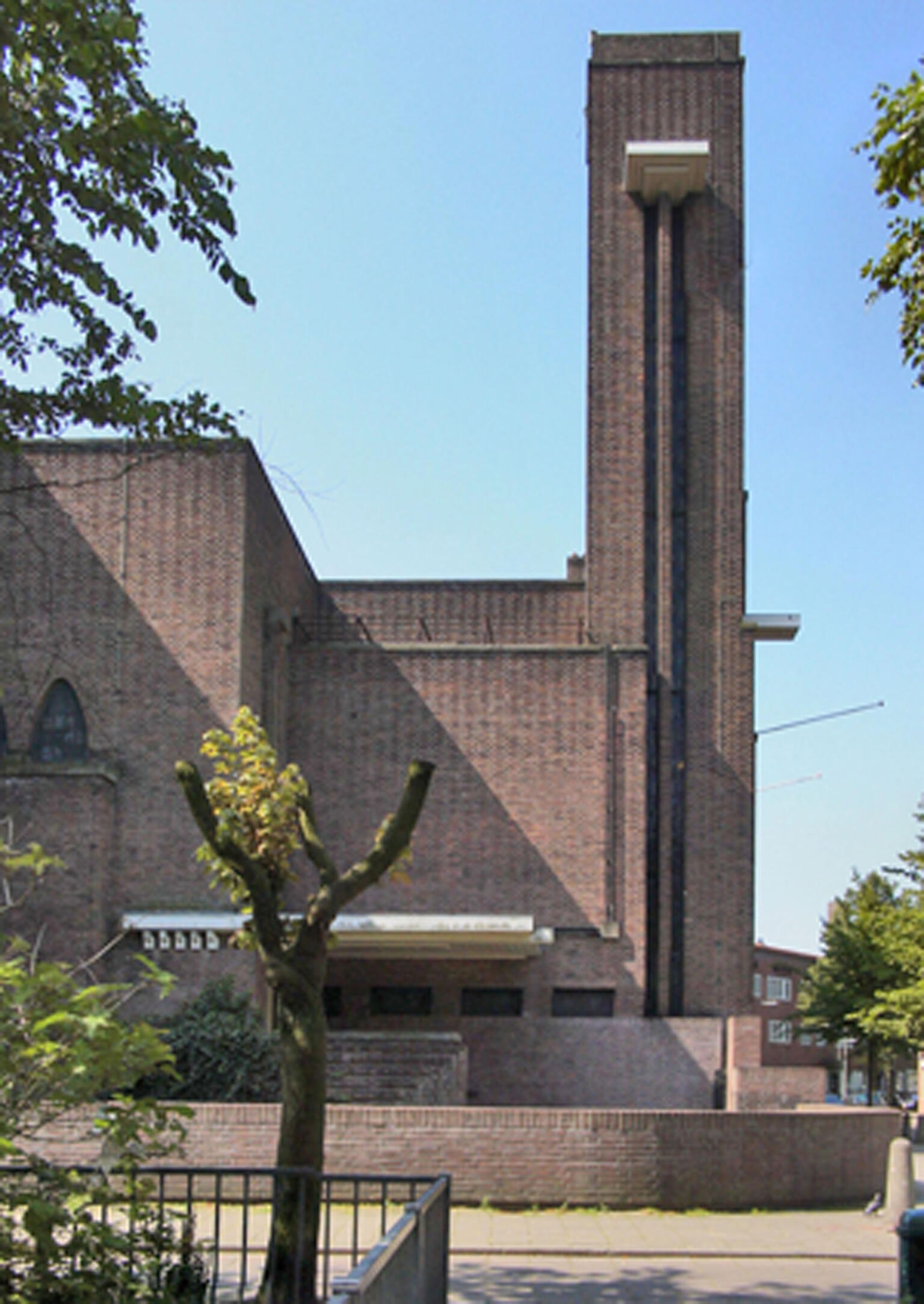 Photograph of brick facade and block shaped tower of building. Photograph of brick facade and block shaped tower of building.
