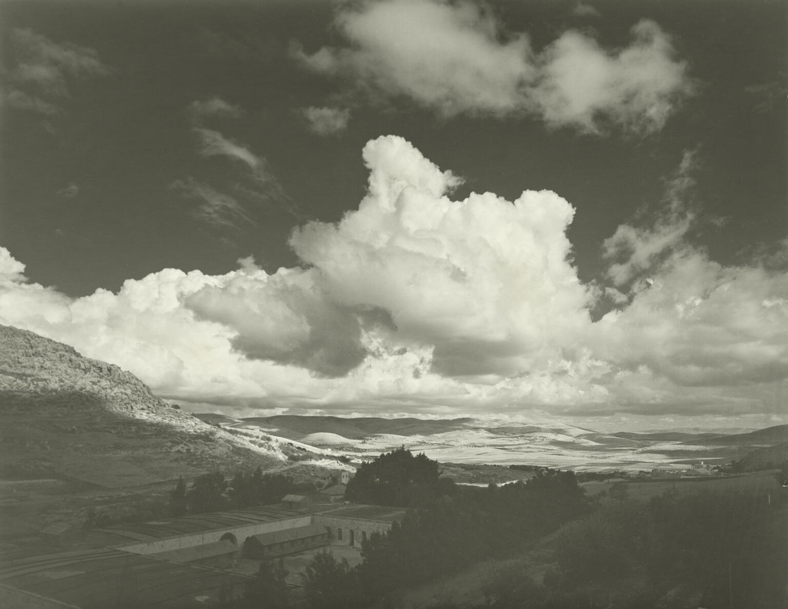 Photograph of valley with buildings under cloudy sky. Photograph of valley with buildings under cloudy sky.