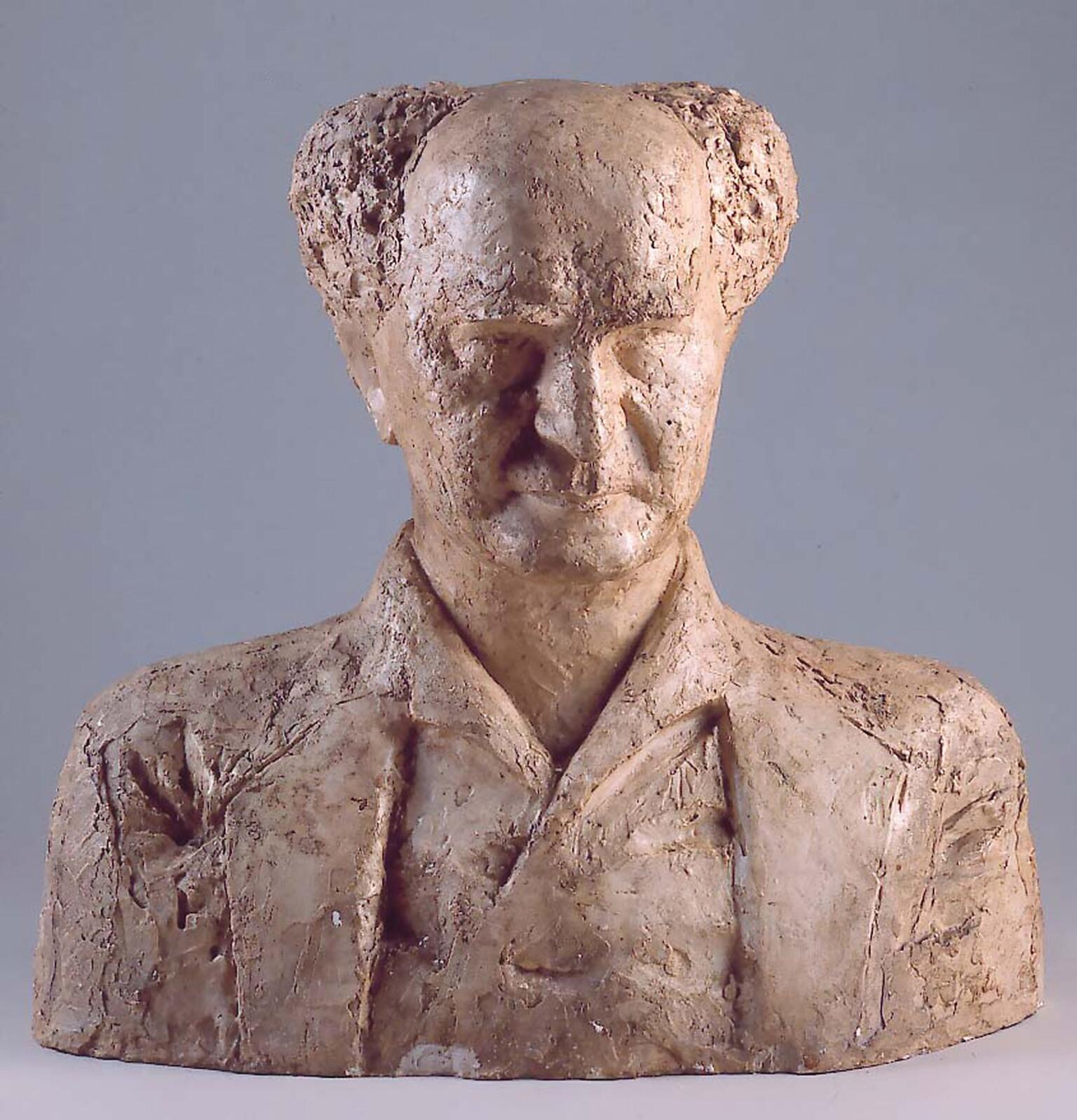 Bust sculpture of an elderly man with central bald spot facing viewer. Bust sculpture of an elderly man with central bald spot facing viewer.