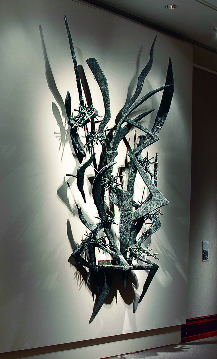Large-scale abstract sculpture of sharp metal lines and edges installed on wall. Large-scale abstract sculpture of sharp metal lines and edges installed on wall.