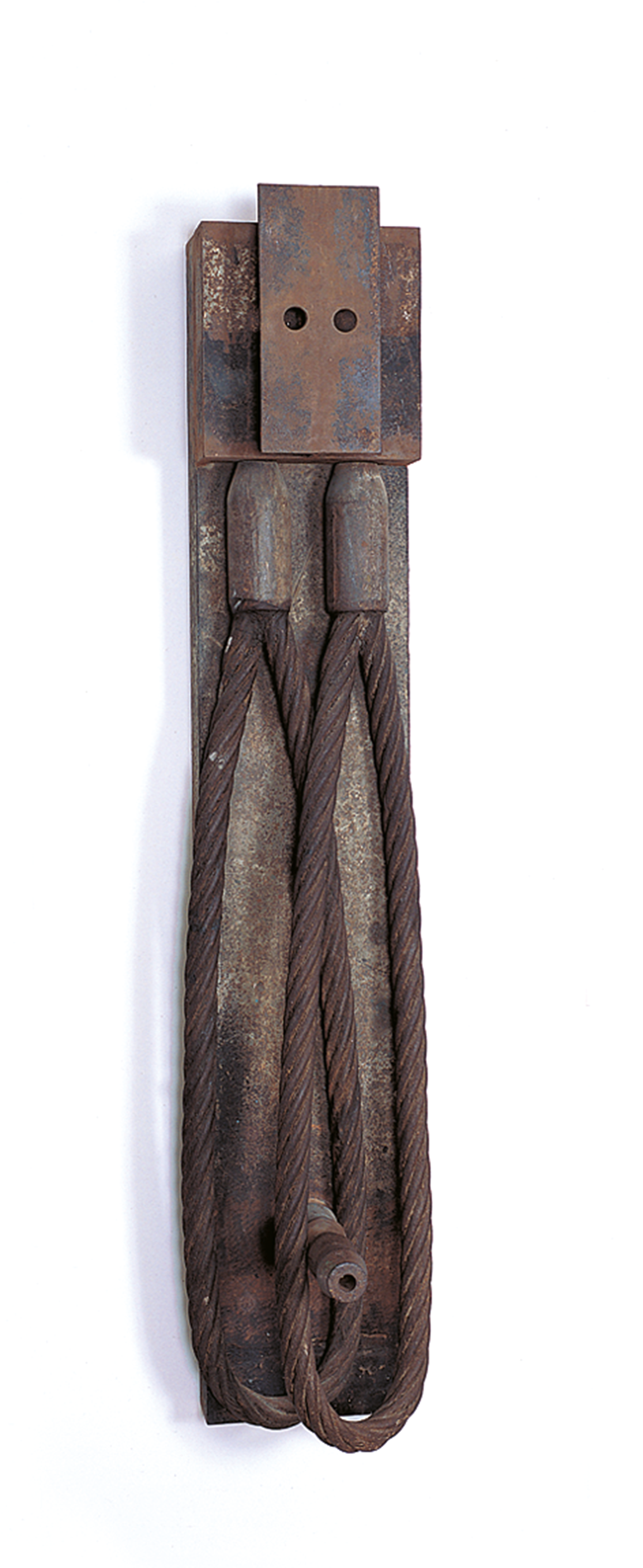 Industrial iron sculpture with two curved cords that meet at the top.