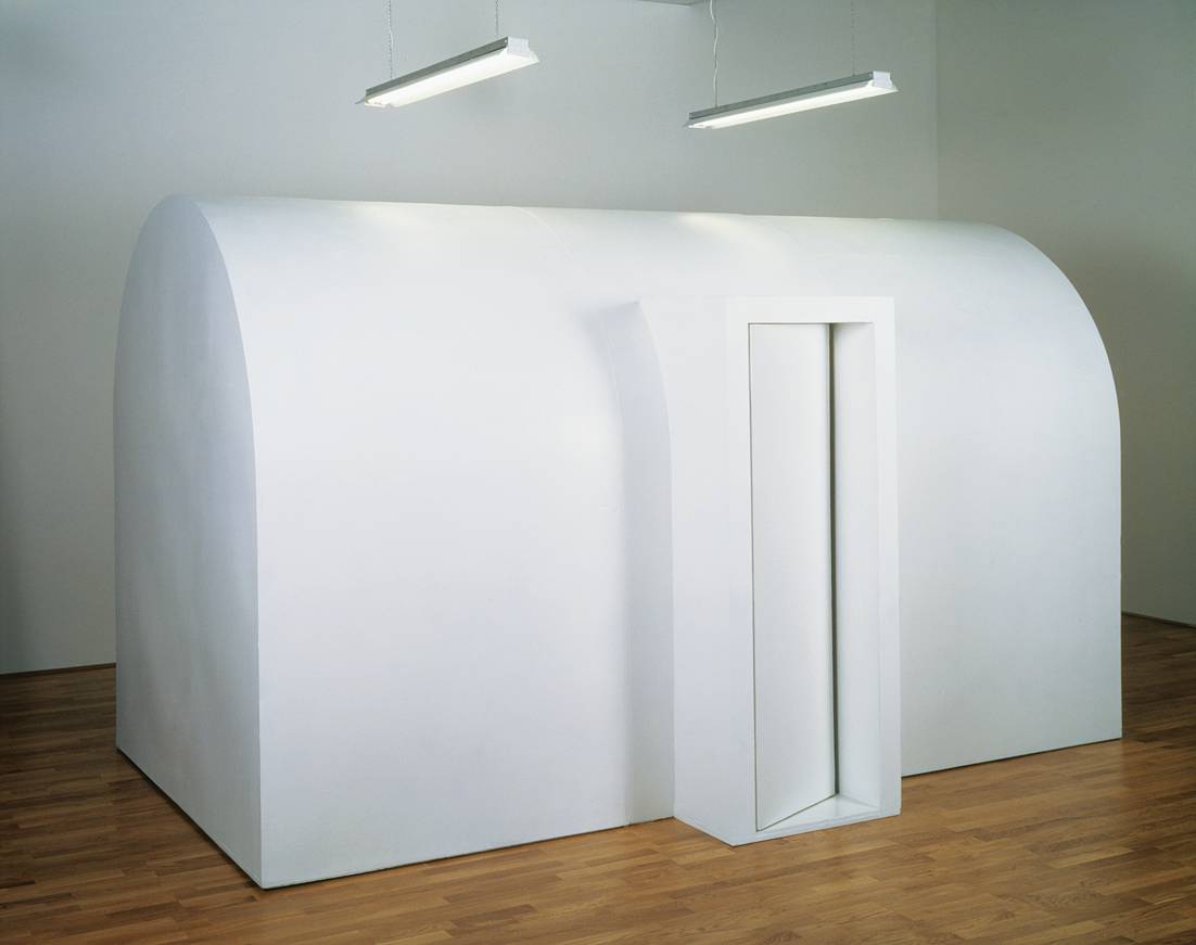 Art installation of large wooden domed structure with curved doorway. 