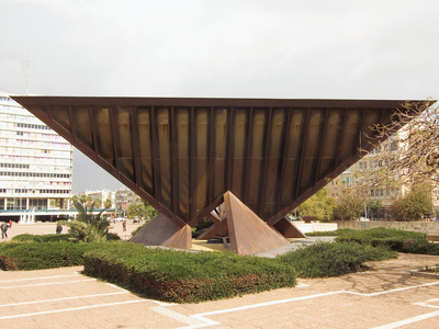 Photograph of inverted pyramid sculpture in the middle of a city square.