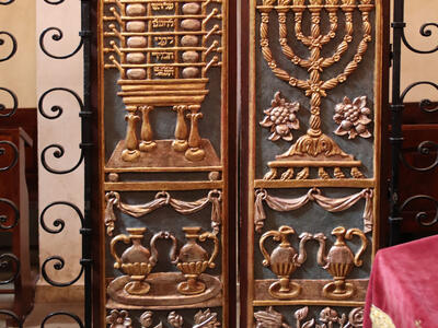 Rema synagogue door detail Set of curved doors with carving of candelabrum, peacock-shaped vessels, and basket of fruit and flowers on right side and table with compartments, peacock-shaped vessels, and basket of fruit and flowers on left side.