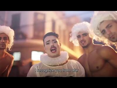 Thumbnail photo of four men, three with white powdered wigs, two of whom are shirtless, with a fourth in make-up and a ruffled collar and white blouse, with an English caption below.