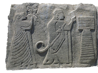 Relief with two figures in profile next to podium and bull.