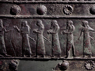 Relief of many figures in a row, some of whom are naked with hands tied behind their backs.
