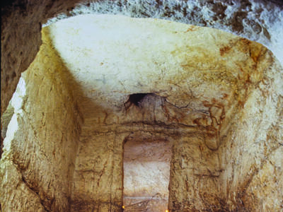 Rectangular chamber in ground with steps and several doorways. 