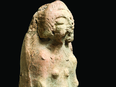 Terra-cotta figurine of pregnant woman cradling belly.