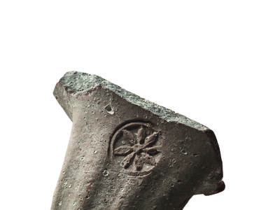 Ceramic piece with impression of flower.