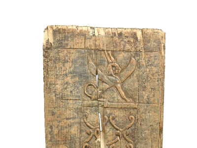 Small ivory plaque with decorative carvings of crouching winged sphinx wearing double crown and two three-tiered palmettes.
