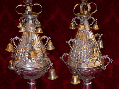 Two silver finials with bells. 