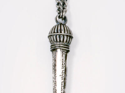 Object with hook and Hebrew imprinted along decorative handle. 