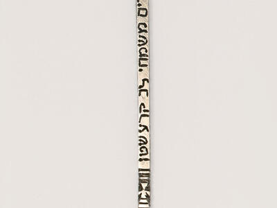 Silver pointer with hand at end and chain at top.