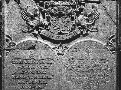 Tombstone with crest on top, and twin columns of text below.