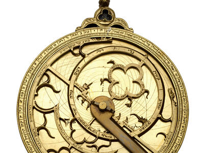 Watch-like device with concentric circles, inner geometric shapes and hands.