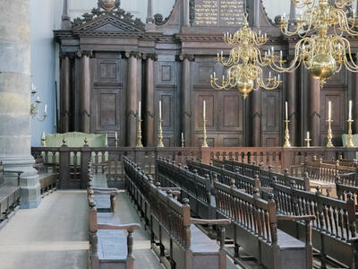 Photograph of room with wooden pews.