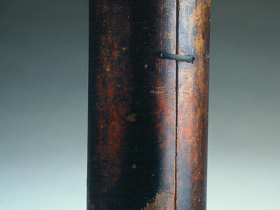Cylindrical case with small ball on top. 