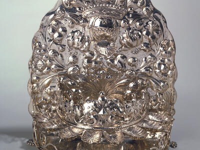Oil lamp stamped with crown and foliage with eight cups on bottom. 