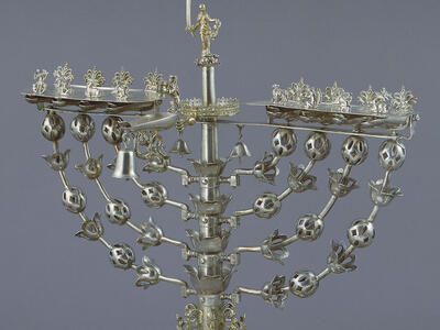Eight-branched candelabrum with figure on top brandishing sword.