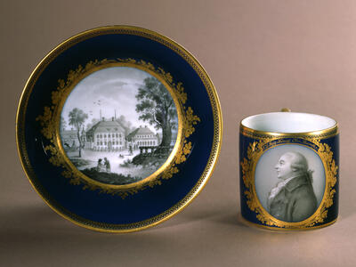 Cup and saucer picturing man in profile on cup and his home on the center of the plate. 
