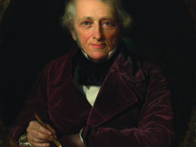 Portrait painting of man facing viewer with left arm resting on table with books and right hand holding dip pen.