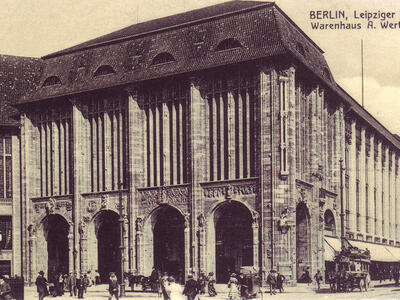 Postcard depicting exterior of building with many columns built into its walls.