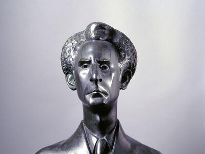 Bust of man in suit and tie.